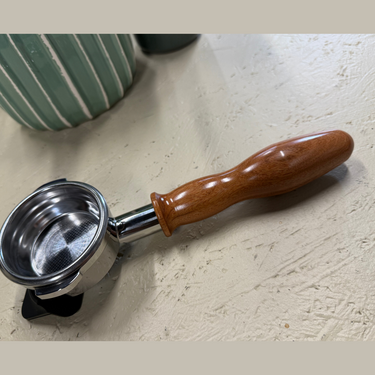 Coffee tamp with wooden handle on a light surface